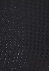 Tissu noir avec un motif de petites perforations rectangulaires espacées régulièrement créant un dégradé allant du dense au clairsemé.