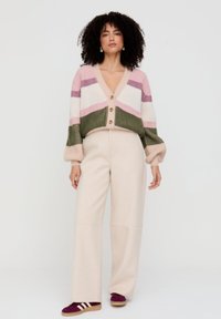 Pullover: kurz geschnitten, gestrickt, mehrfarbige Streifen in Rosa, Grün und Creme, mit tiefem V-Ausschnitt und fünf Knöpfen. Weite, cremefarbene Hose.