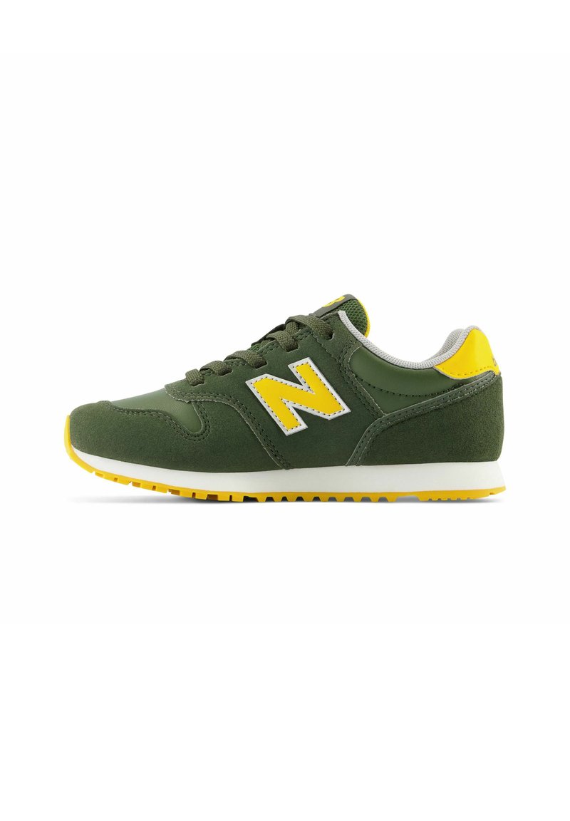 Baskets en daim vert avec des accents jaunes, semelle intermédiaire blanche et semelle extérieure en caoutchouc texturé. Présente un logo "N" jaune bien visible sur le côté.