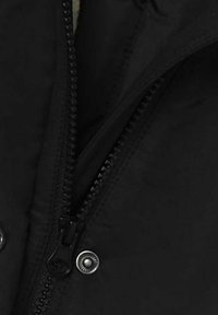 Schwarze Jacke mit Reißverschluss und Druckknopf, mit einer glatten, matten Textur. Der Reißverschluss befindet sich in der Mitte und ist teilweise geöffnet, wodurch das gefütterte Innere sichtbar wird.