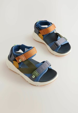 Sandales d'extérieur bleues et grises avec des sangles multicolores ; dotées de velcro réglable, de semelles en caoutchouc et d'une semelle intérieure texturée pour le confort.