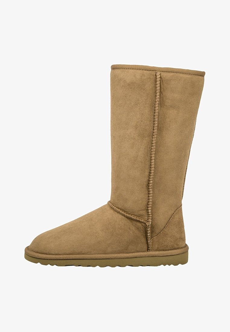 Vaaleanruskea mokkanahkainen pitkä saapas, jossa pyöreä kärki ja sivusauman tikkaus. Varustettu tasapohjaisella kumipohjalla ja pehmeällä vuorella mukavuutta varten.