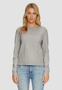 Grijze sweatshirt met lange mouwen, gemaakt van zacht materiaal, met een ronde halslijn en ribgebreide manchetten, gecombineerd met lichtblauwe jeans.