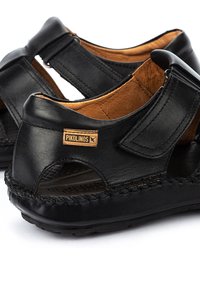 Schwarze Leder-Casual-Sandalen mit verstellbarem Riemen und gepolsterter Sohle, mit einem Pikolinos Markenlabel an der Seite.