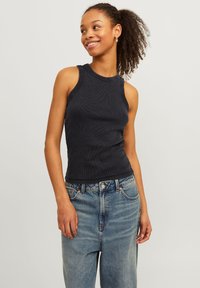 Mørk marineblå ribbet tanktop med rund hals, ermeløs design og figurnær silhuett, sammen med lyseblå vide bukser.