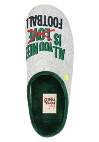 Zapatilla de casa gris con forro interior verde. El texto dice "TODO LO QUE NECESITAS ES AMOR" con "AMOR" tachado en rojo. Presenta un pequeño acento verde.