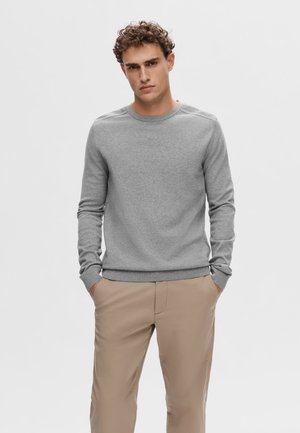 Lichtgrijze sweatshirt met ronde hals en lange mouwen, met ribbelboorden en een ribbelzoom. Gecombineerd met beige broek, casual en eenvoudig ontwerp.