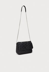 Μαύρη καπιτονέ τσάντα χειρός με αλυσίδα και δερμάτινη επάνω λαβή. Διαθέτει κλείσιμο με καπάκι και λογότυπο στο μπροστινό μέρος. Ομαλή υφή.