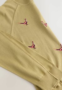 Olijfgroen sweatshirt met geribbelde manchetten, met kleurrijke vogelborduursels over de stof. Zachte textuur en een ontspannen pasvorm.