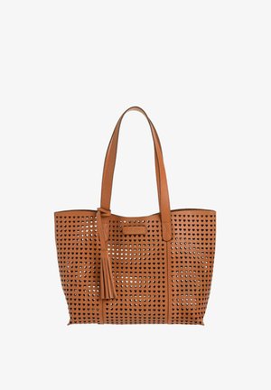 Sac fourre-tout en cuir marron avec des perforations en forme de cœur, double poignées et un accent pompon sur un côté.