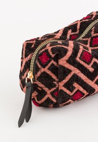 Tekstilpose med geometriske mønstre i sort, rød og pink. Har en guldlås og en sort læder lynlås trækflap. Rektangulært design.