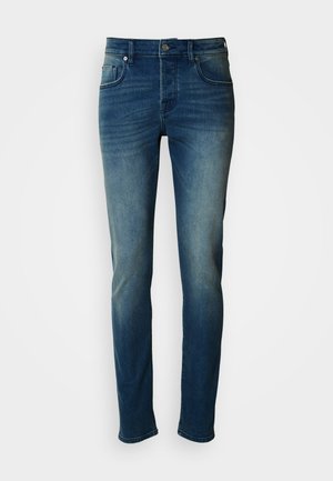 Dżinsy z denimu w średnim niebieskim odcieniu, o dopasowanym kroju, prostych nogawkach, z pięcioma kieszeniami oraz subtelnym wyblaknięciem na udach i kolanach.