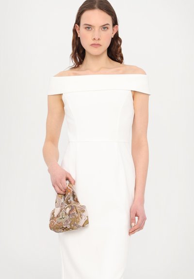 Vestido branco sem alças com um corpo justo e uma parte inferior expandida, segurando uma pequena bolsa de mão com contas em cores pastel e padrões florais.