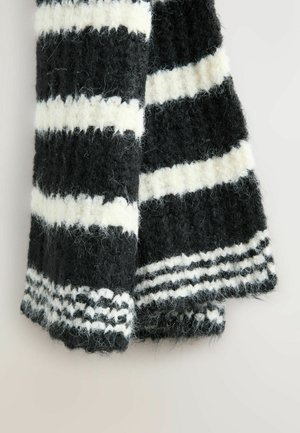 Black and white striped wool scarf, featuring fuzzy texture, thick knit, and a woven pattern at the ends with alternating stripes.