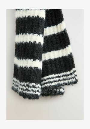 Czarnobiała, w paski wełniana chusta, z puszystą teksturą, grubym splotem i plecionym wzorem na końcach, z naprzemiennymi paskami.