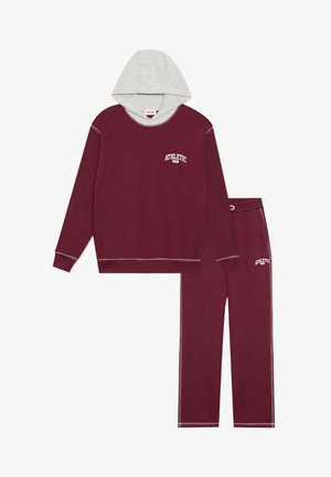Burgundowa bluza z szarym kapturem, z logo "ATHLETIC". Pasujące burgundowe spodnie o miękkiej teksturze, luźnym kroju, z kontrastującymi detalami szycia.
