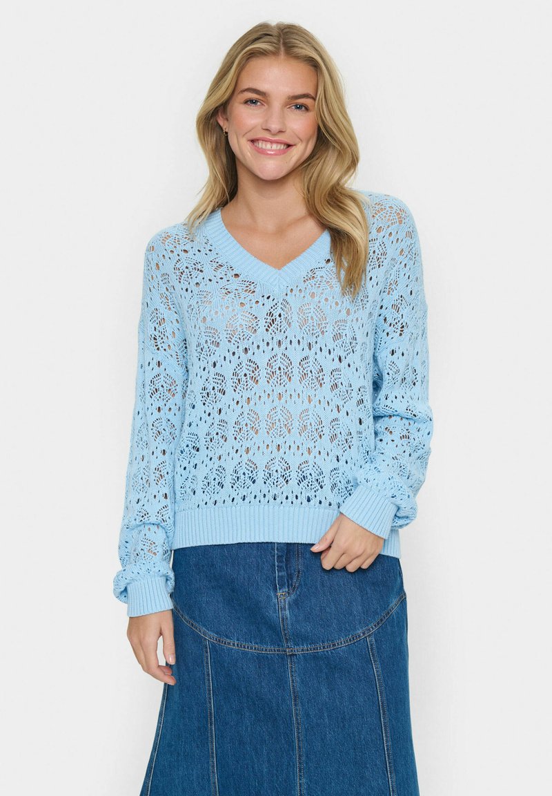 Jasnoniebieski sweter z dzianiny z dekoltem w kształcie litery V, z otwartym, koronkowym wzorem. Rękawy i dół z ściągaczem. Nosić na denimu spódnicy.