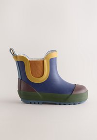 Bottine courte imperméable bleue avec bordure jaune, semelle verte, bout et talon marron, et panneau latéral élastique orange.