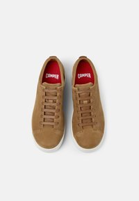 Brown leather sneakers with beige laces, round toe, white rubber sole, and red interior featuring "CAMPER" logo on the tongue.