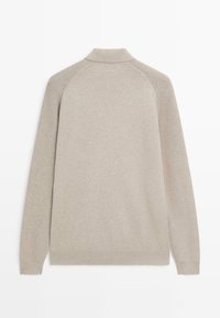 Maglione beige con collo ripiegato, maniche raglan e una morbida texture a maglia. Design semplice con dettagli a coste sull'orlo e sui polsini.