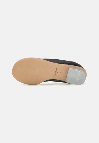 Scarpa in tessuto nero con punta tonda, suola in gomma e accentuazione trasparente sul tallone. Design piatto e texture liscia.
