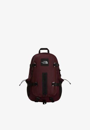 Ciemnoczerwony plecak North Face z wieloma paskami, siateczkowymi kieszeniami bocznymi, górnym uchwytem i naszywką z logo z przodu, wyśrodkowany na białym tle.