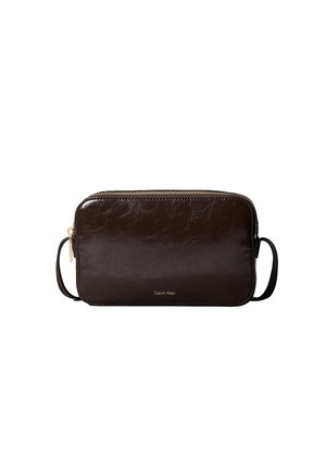 Sac bandoulière rectangulaire en cuir marron foncé avec fermeture éclair dorée et fine bandoulière, petit logo Calvin Klein centré sur le devant.