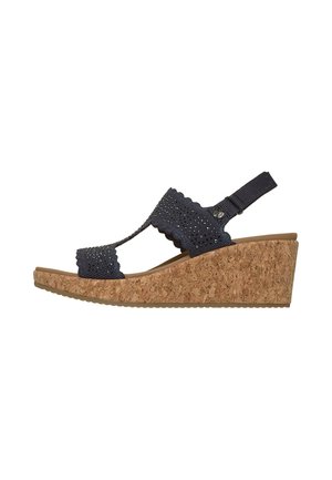 Sandalia cuña con suela de corcho y tiras de tela negra con pequeñas perforaciones y borde festoneado, punta abierta y tira trasera.