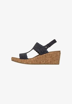 Sandalia cuña con suela de corcho y tiras de tela negra con pequeñas perforaciones y borde festoneado, punta abierta y tira trasera.