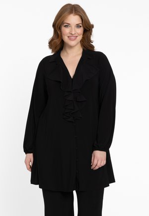 Zwarte blouse met lange mouwen, knopen aan de voorkant en een kraag met ruches. Gemaakt van zachte stof met een losse pasvorm.