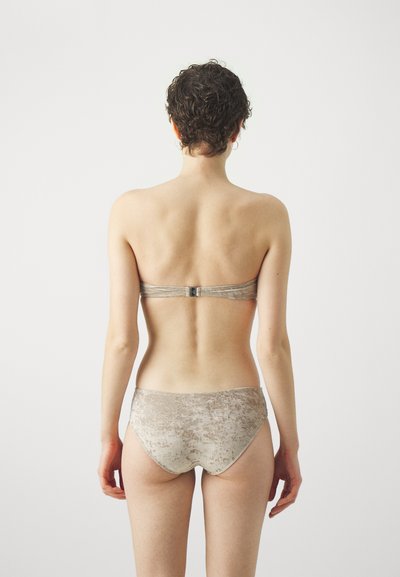 Divi daļīgā bikini gaiši bēšā tonī; mīksta, samtainā tekstūra; bezsiksnu augšdaļa ar sudraba spiedpogu; augsto vidukli apakšdaļa ar gludu apdari.