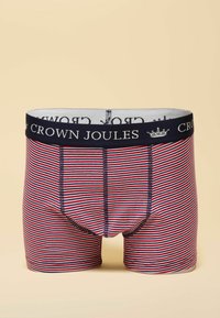 Men's boxer shorts featuring a red and white striped pattern, a navy elastic waistband with "CROWN JOULES" text, and a classic fit design.