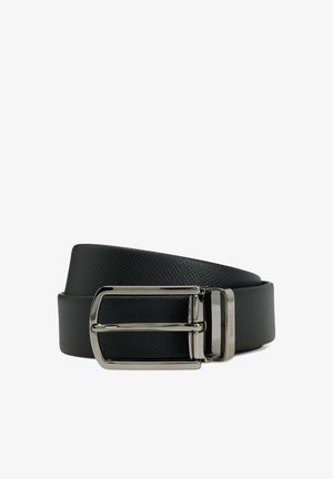 Musta, teksturoitu nahkainen vyö, jossa kiiltävä hopeanvärinen suorakulmainen solki, rullattu valkoisella taustalla.