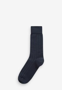 Marineblaue Socke mit einem strukturierten Muster, ausgestattet mit einem gerippten Bündchen und einer nahtlosen Spitze. Das Material wirkt weich und dehnbar.