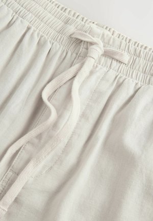 Helle beige Leinen-Shorts mit elastischem Bund und Kordelzug. Verfügt über eine weiche Textur und gestickte Details auf dem Stoff.
