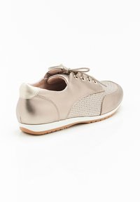 Sneaker beige metallizzato con dettagli in rete, punta rotonda, chiusura con lacci e suola bianca a contrasto. Tessuto morbido con una finitura liscia.