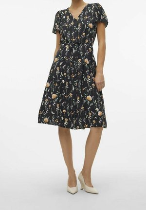 Kukkamekko, jossa musta pohja, lyhyet liehukkeet hihat, V-aukko, vyötärönauha, liehukehelmainen hame ja sivutaskut. Koristeltu monivärisillä kukilla.