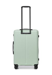 Valigia rigida di colore verde menta con texture rigata, manico retrattile nero e quattro ruote nere per la mobilità.