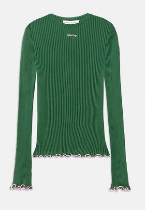 Top verde de manga larga con cuello redondo y puños acampanados, que presenta bordes en forma de ola en rosa y un pequeño logo bordado en el pecho.
