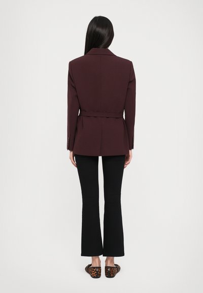 Maroon tailored blazer with a belt at the waist, paired with black flared pants and leopard print flats. Smooth fabric with structured design.