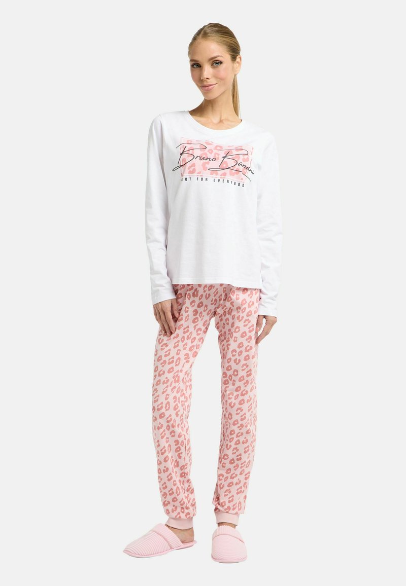 Weißes Langarmshirt mit grafischem Text, kombiniert mit rosa Leopardenmuster-Hose und rosa gestreiften Hausschuhen. Weiche Materialien und lockere Passform.