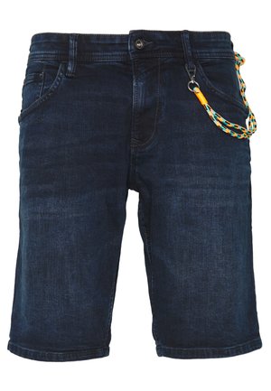 Des shorts en denim sombre présentent une texture lisse, une poche avant et un cordon coloré attaché à une boucle sur la ceinture.