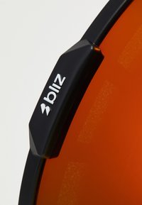 Sportsolbriller med en sort ramme, orange linser og logo detalje. Rammen har teksturerede accenter for greb og holdbarhed.