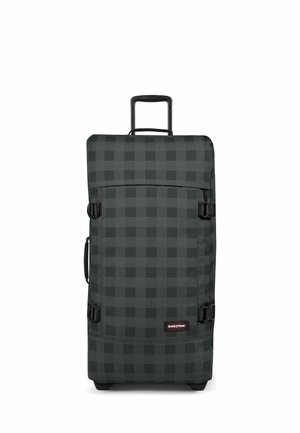 Maleta alta de ruedas con estampado de cuadros negros y grises, asa extensible, asa lateral, correas de compresión y logo de Eastpak en la esquina inferior frontal.