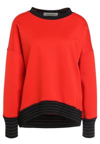 Sudadera roja con dobladillo y puños a rayas negras. Presenta un cuello redondo y hombros caídos. Fabricada en un tejido suave y elástico.