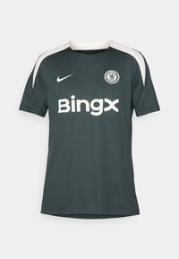 Mørkegrøn fodboldtrøje lavet af åndbart materiale, med hvide accenter på skuldrene, et cirkulært Chelsea-logo og "Bingx"-logoet i hvid.