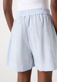 Lichtblauwe gestreepte shorts met een elastische tailleband, gemaakt van een lichtgewicht stof, met dunne contrasterende lijnen en een relaxte pasvorm.