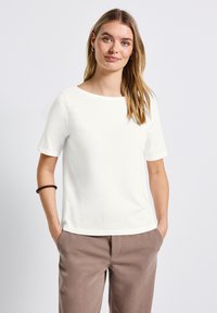 Maglietta bianca a maniche corte con scollatura rotonda. Realizzata in tessuto liscio, presenta una vestibilità comoda e un design semplice e minimalista.
