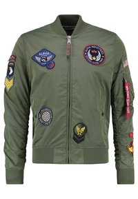 Giacca bomber verde oliva, materiale nylon, polsini e orlo a coste, zip frontale, numerosi toppe colorate sul petto e sulle maniche.