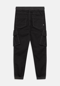 Svarta cargobyxor med elastisk midja, flera sidofickor och kontrasterande sömmar. Slim fit med avsmalnande ben och textilerad tyg.